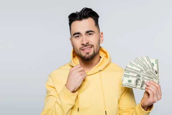 Bookmaker with dollar banknotes smiling at camera isolated on grey — Photo de stock