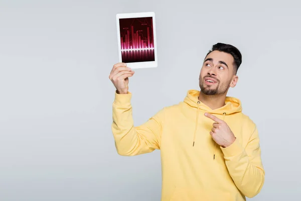 Uomo sorridente che punta al tablet digitale con grafici isolati su grigio — Foto stock