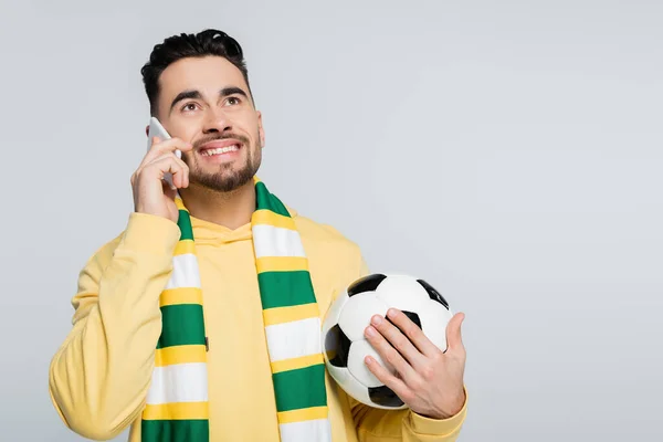 Fanático del fútbol feliz hablando en el teléfono inteligente aislado en gris - foto de stock