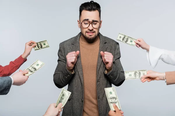 Confused critic standing with clenched fists near people with money isolated on grey — Stock Photo