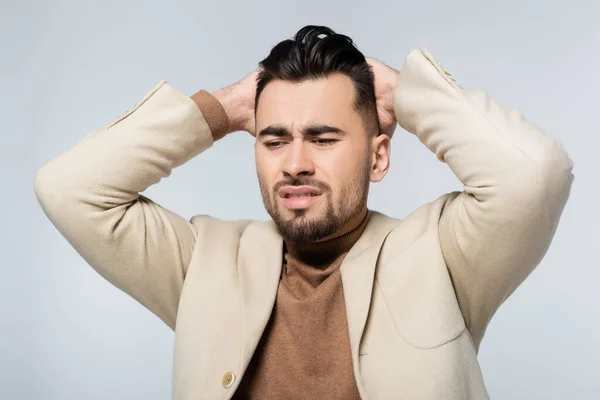 Frustrated critic holding hands behind head isolated on grey — Foto stock