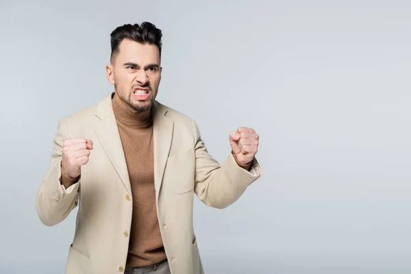 Angry critic grimacing and showing clenched fists isolated on grey — Foto stock