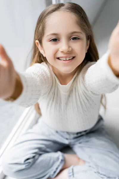 Excitada chica con las manos extendidas mirando a la cámara - foto de stock