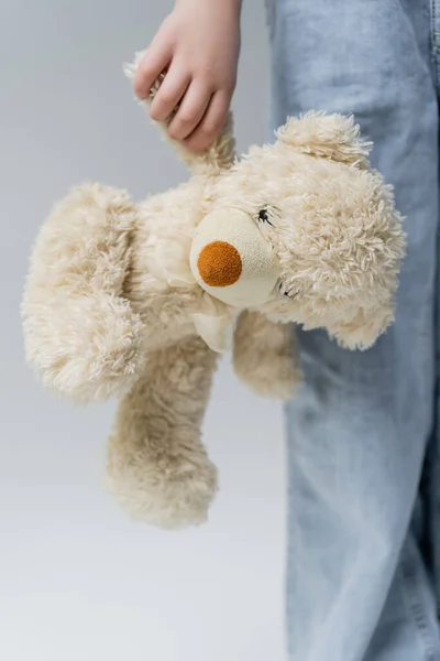 Cropped view of child with teddy bear isolated on grey — Stock Photo