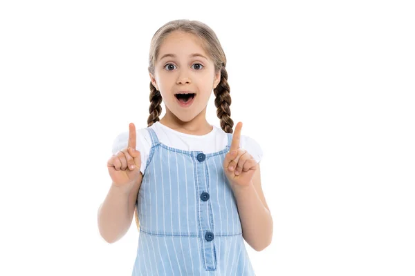 Amazed girl in blue strap dress pointing up with fingers isolated on white — Stock Photo