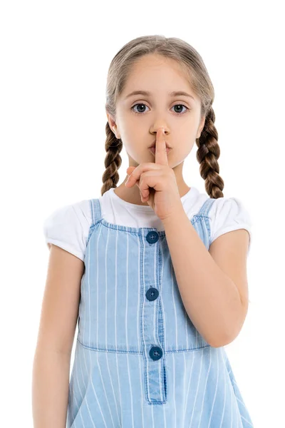 Chica en vestido de correa azul que muestra signo de silencio mientras mira a la cámara aislada en blanco - foto de stock