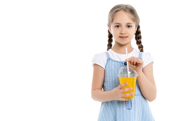 Mädchen mit Zöpfen und Plastikbecher mit Orangensaft blickt isoliert auf weiße Kamera — Stockfoto