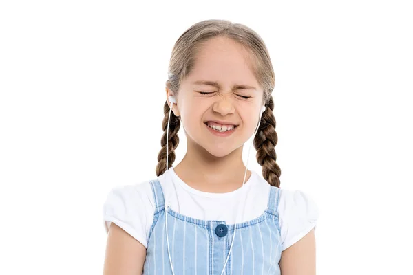 Chica excitada en auriculares con cable de pie con los ojos cerrados aislados en blanco - foto de stock