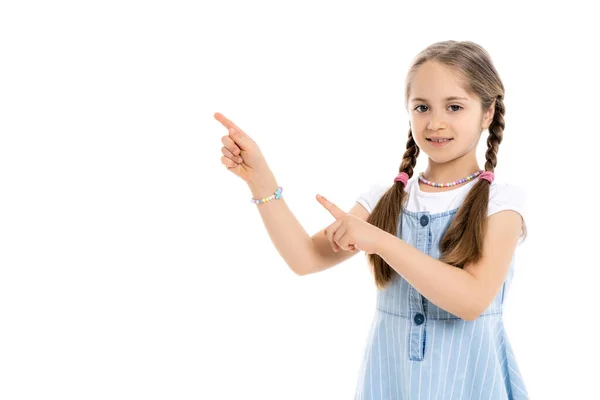 Menina com tranças e contas multicoloridas apontando para longe com os dedos isolados no branco — Fotografia de Stock