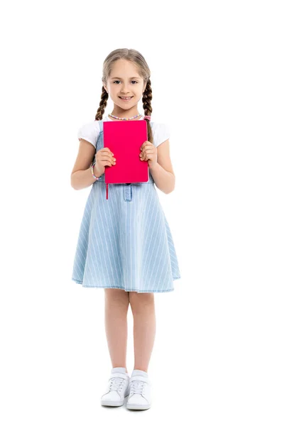 Full length view of happy girl holding bright pink copy book on white — Stock Photo