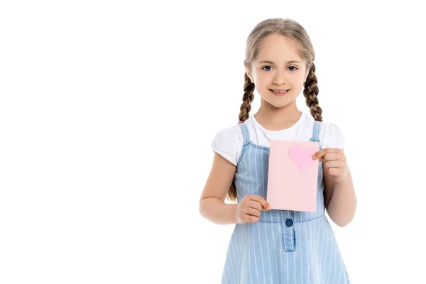 Cheerful girl holding pink card with paper heart isolated on white — Stock Photo