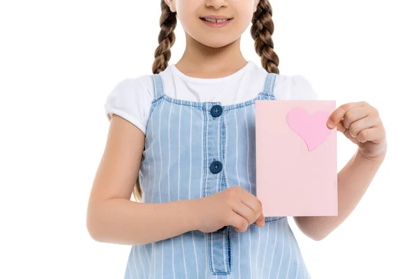 Vista ritagliata della ragazza sorridente in abito cinturino blu con carta in mano con cuore rosa isolato su bianco — Foto stock