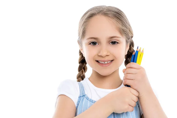 Alegre chica ucraniana sosteniendo lápices azules y amarillos aislados en blanco - foto de stock