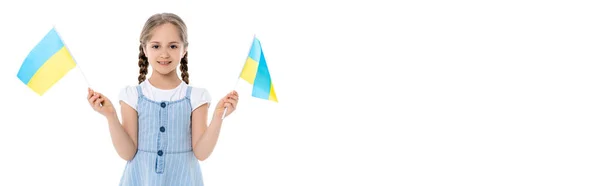 Fille en robe de sangle bleue tenant de petits drapeaux ukrainiens isolés sur blanc, bannière — Photo de stock