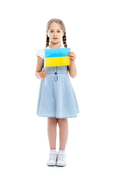 Vue pleine longueur de fille en robe bleue tenant petit drapeau ukrainien sur blanc — Photo de stock