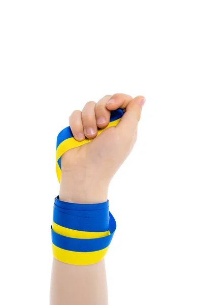 Vista parcial del niño sosteniendo cinta azul y amarilla aislada en blanco - foto de stock
