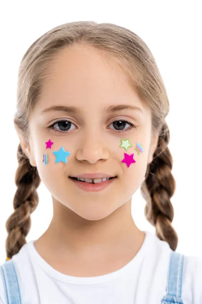 Retrato de chica feliz con trenzas y estrellas multicolores en la cara aislada en blanco - foto de stock