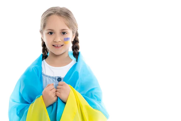 Patriotic ukrainian girl with national flag on shoulders looking at camera isolated on white — Stock Photo