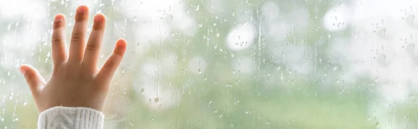 Teilansicht des Kindes, das nasses Fensterglas berührt, Banner — Stockfoto