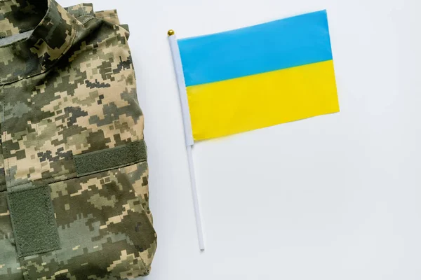 Vista superior del uniforme militar y la bandera ucraniana sobre fondo blanco - foto de stock