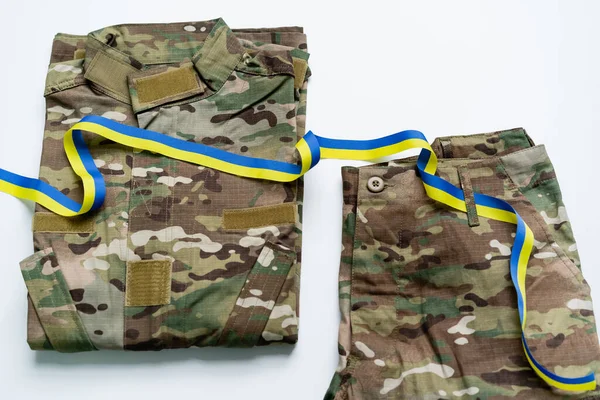 Vista superior de la cinta azul y amarilla en uniforme militar sobre fondo blanco - foto de stock