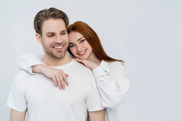 Positivo jovem mulher abraçando namorado isolado no branco — Fotografia de Stock