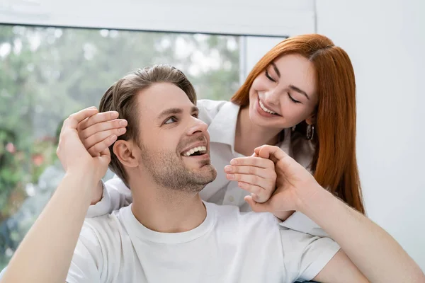 Smiling man holding hands of young girlfriend at home — Stock Photo