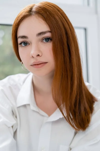 Portrait of red haired woman looking at camera at home — Stock Photo