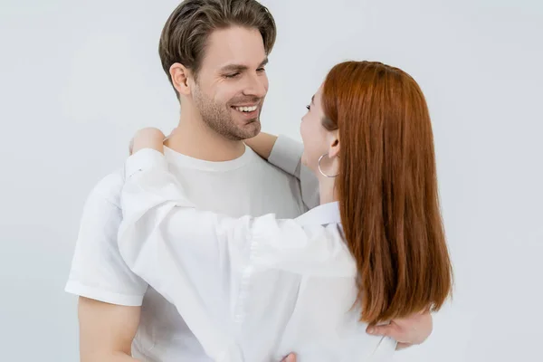 Jovem ruiva mulher abraçando namorado isolado no branco — Fotografia de Stock