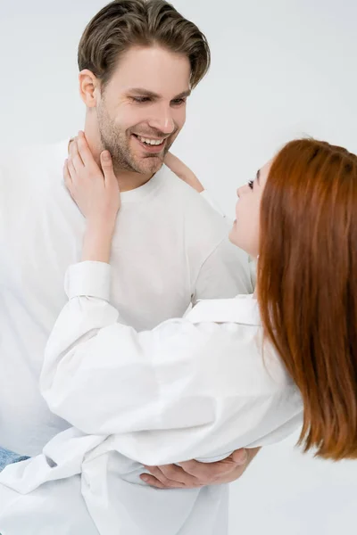 Donna offuscata toccando sorridente fidanzato isolato su bianco — Foto stock