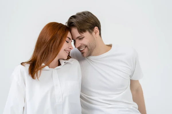 Happy young couple smiling with closed eyes isolated on white — Stock Photo