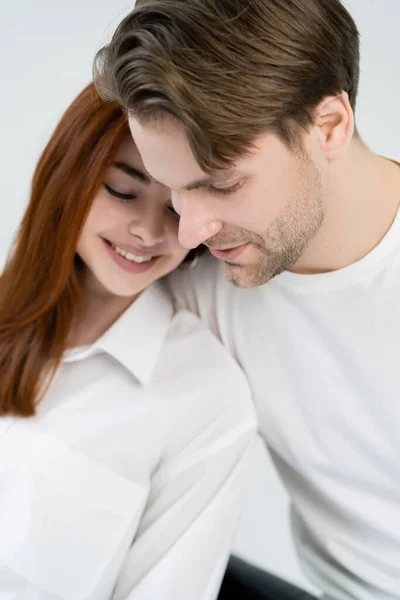 Giovane uomo guardando lontano vicino ragazza offuscata in camicia isolata su bianco — Foto stock