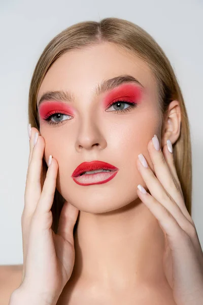 Woman with red visage touching face isolated on grey — Stock Photo