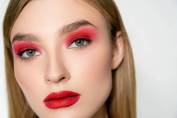 Portrait of young model with red visage looking at camera isolated on grey — Stock Photo