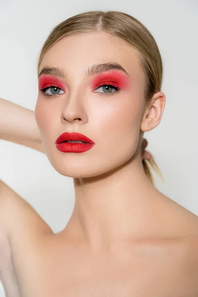 Hellhaariges Model mit rotem Make-up blickt vereinzelt in die Kamera auf grau — Stockfoto