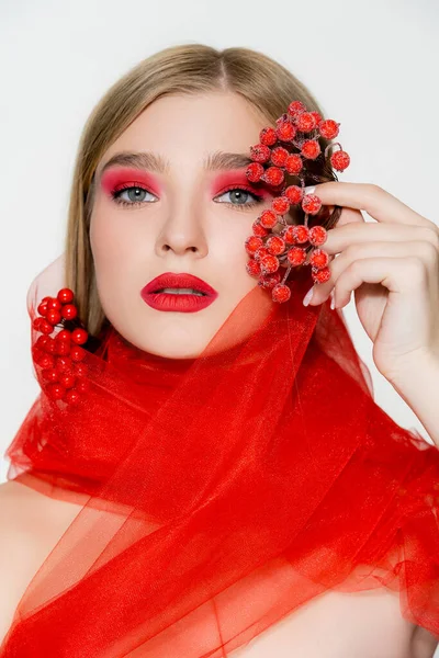 Modelo com maquiagem e pano vermelho segurando bagas isoladas em branco — Fotografia de Stock