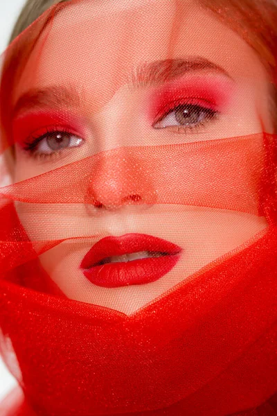 Close up view of young model with red lips looking at camera near cloth isolated on white — стоковое фото