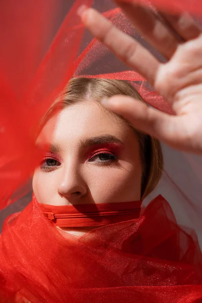 Femme aux cheveux clairs avec fermeture éclair rouge sur la bouche tenant un tissu sur fond gris — Photo de stock