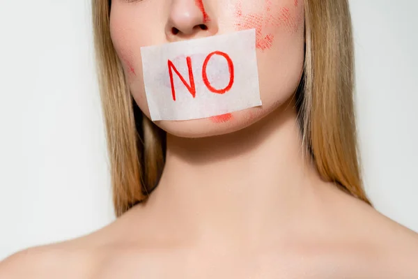 Cropped view of woman with blood on face and card with lettering no isolated on grey — стоковое фото