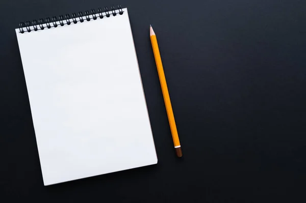 Draufsicht auf leeres Notizbuch und Bleistift auf Schwarz — Stockfoto