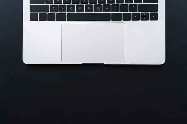 Vue de dessus du clavier d'ordinateur portable et du pavé tactile sur noir — Photo de stock