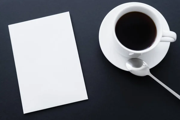 Top view of plank paper near cup of coffee on black — Photo de stock