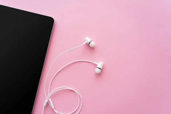 Ansicht von oben digitales Tablet mit leerem Bildschirm in der Nähe von Kopfhörern auf rosa — Stockfoto