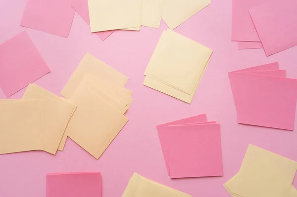 Vista superior de las notas de papel vacías en rosa - foto de stock