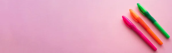 Top view of colorful and bright pens on pink, banner — Stock Photo