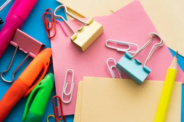Close up view of colorful paper clips and fold back clips on paper notes — Photo de stock
