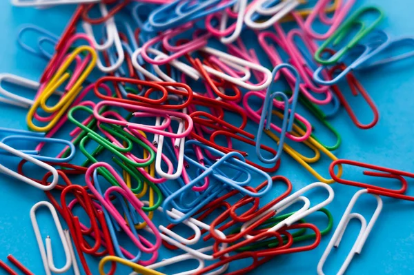 Close up view of colorful paper clips on blue — Fotografia de Stock