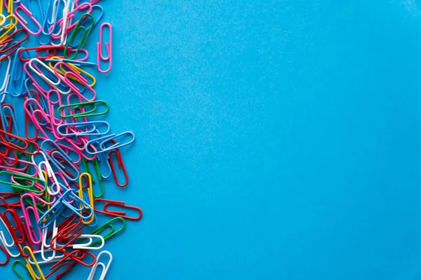 Top view of colorful paper clips on blue — Stock Photo