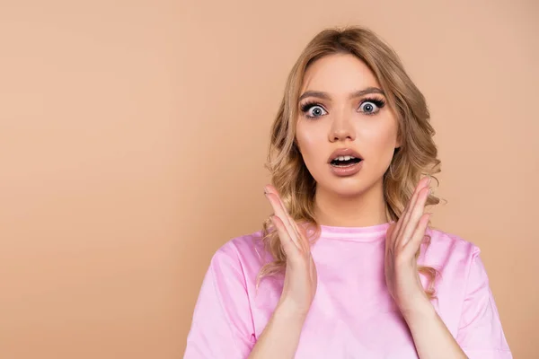 Astonished woman with open mouth showing wow gesture isolated on beige — Fotografia de Stock