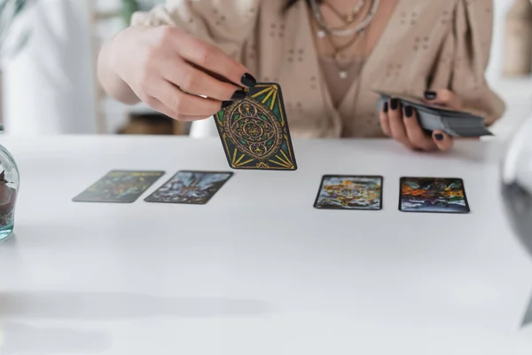 KIEW, UKRAINE - 23. FEBRUAR 2022: Ausgeschnittene Ansicht eines verschwommenen Mediums mit Tarot-Karten zu Hause — Stockfoto